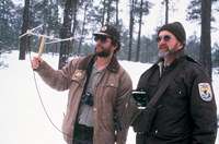 Two biologists locating a collared wolf with radio telemetry.